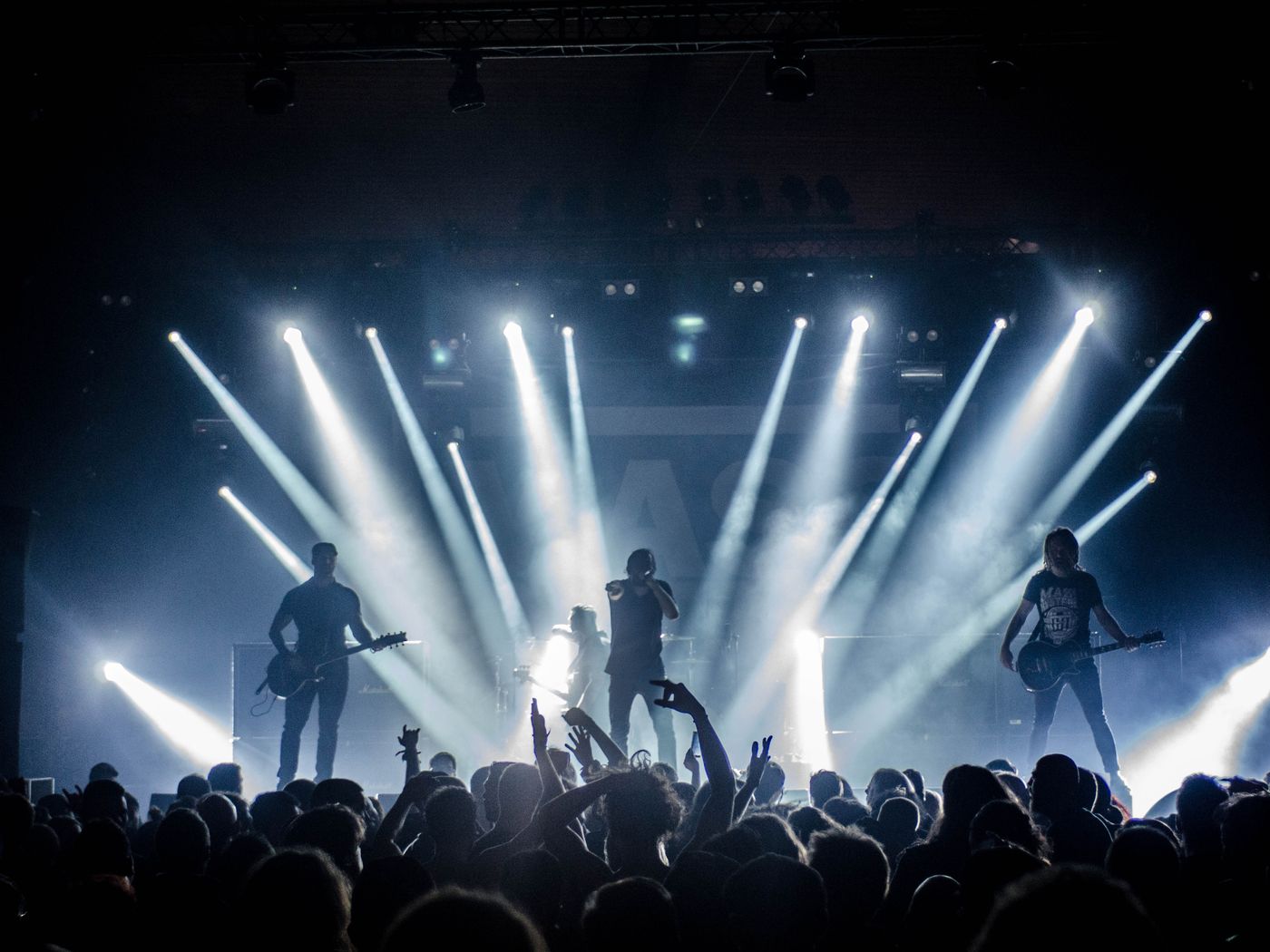 A band on a lit stage in front of a crowd